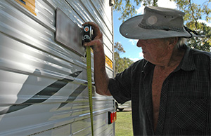 A caravanner checks the height of his number plate